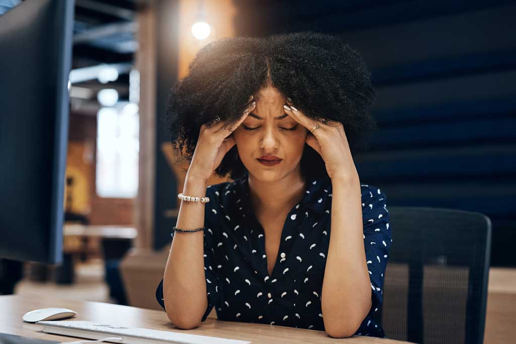 Female-experiencing-headache-at-work,-a-symptom-of-chronic-rhinitis