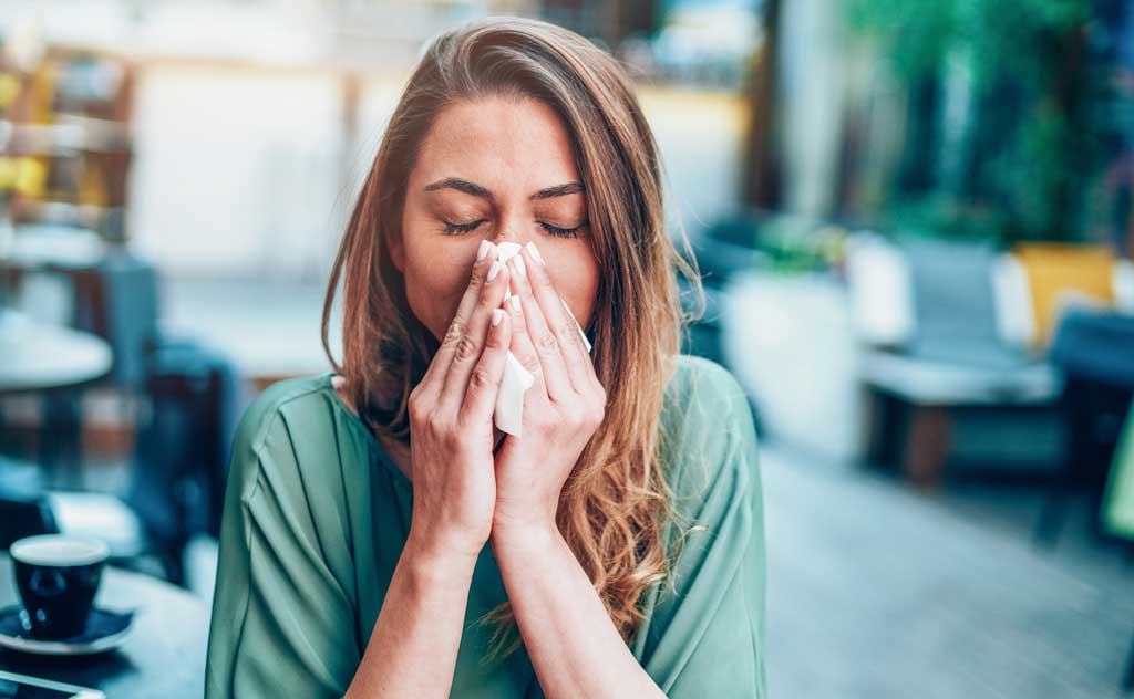 Woman-blowing-her-nose,-experiencing-symptom-of-chronic-rhinitis