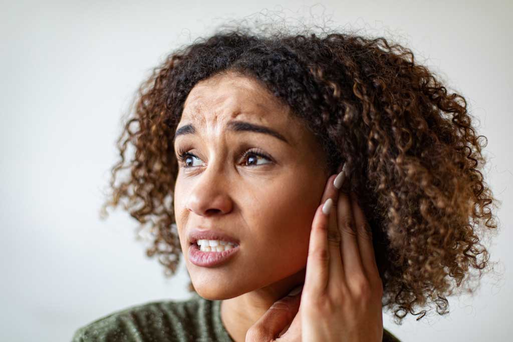 Woman-touching-her-ear-in-pain-and-experiencing-symptoms-of-chronic-tonsillitis
