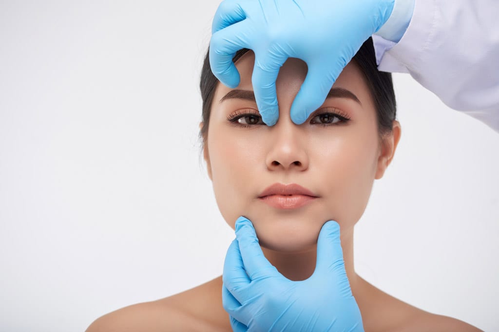 Surgeon-evaluating-a-woman’s-face-before-nasal-surgery-in-Beverly-Hills