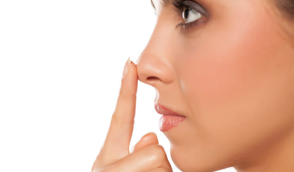 Woman-touching-her-nose,-showing-potential-results-of-nasal-surgery-in-Beverly-Hills