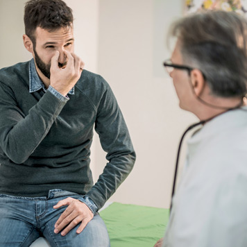 Male-adult-patient-describing-his-need-for-a-septoplasty-to-a-male-physician Male-adult-patient-describing-his-need-for-a-septoplasty-to-a-male-physician