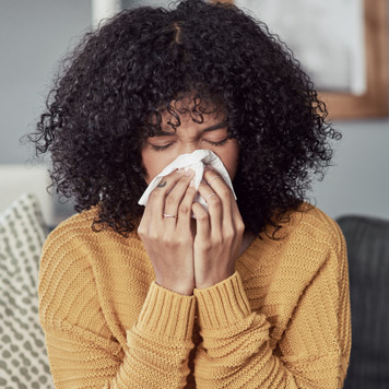 Young-woman-blowing-her-nose-into-a-tissue-and-needing-to-visit-the-best-ENT-Doctor-in-Beverly-Hills Young-woman-blowing-her-nose-into-a-tissue-and-needing-to-visit-the-best-ENT-Doctor-in-Beverly-Hills
