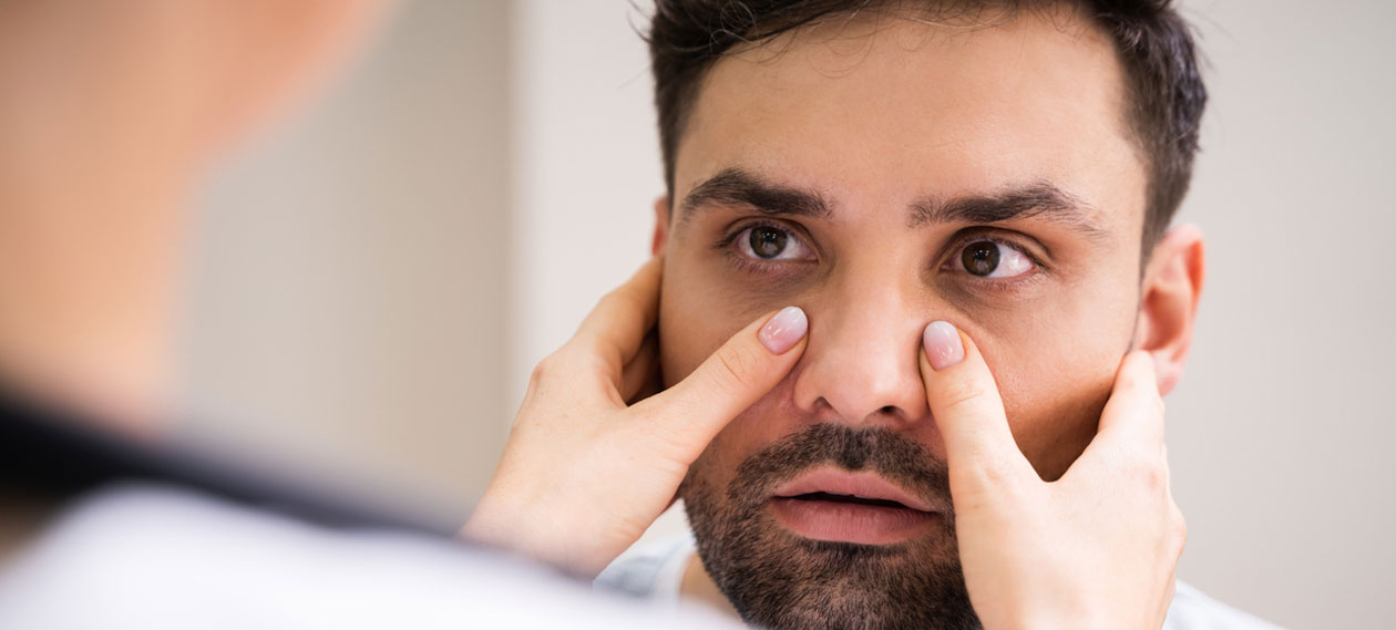 doctor-examining-a-man's-nose-and-cheeks-during-an-exam