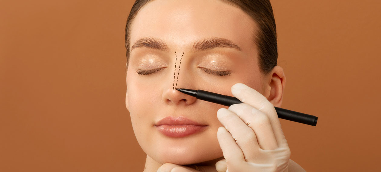 gloved-hand-marking-a-woman's-nose-with-a-pencil