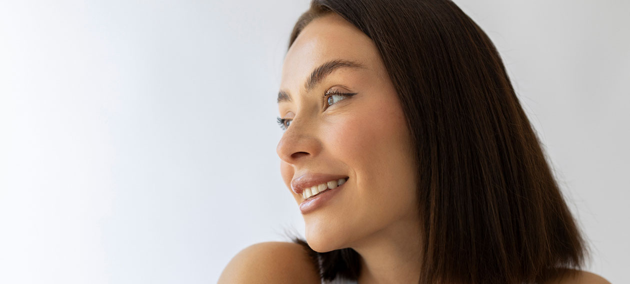 smiling-woman-in-profile-against-a-light-background